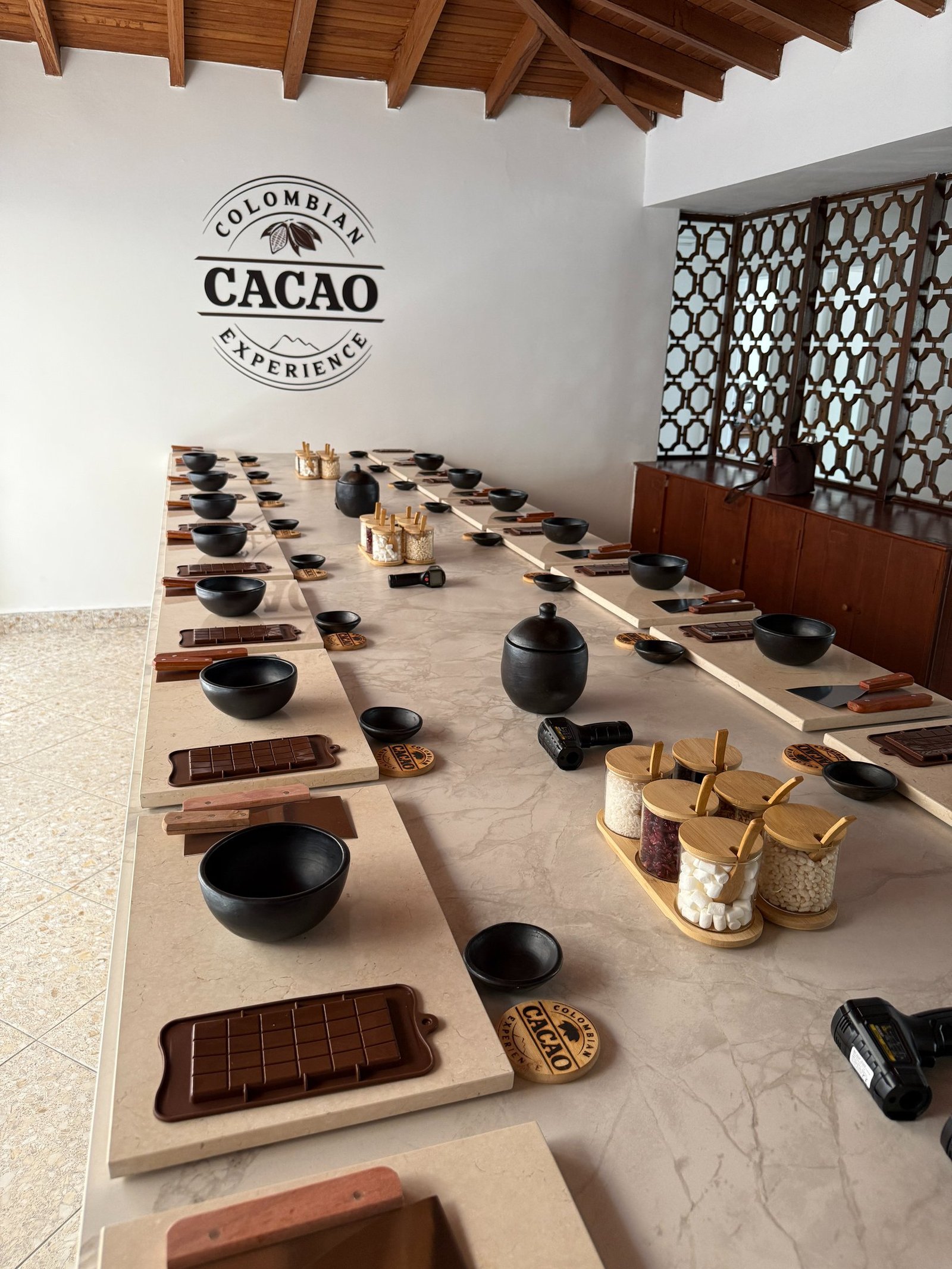 Colombian cacao experience chocolate making workshop table with molds, bowls, and ingredients.